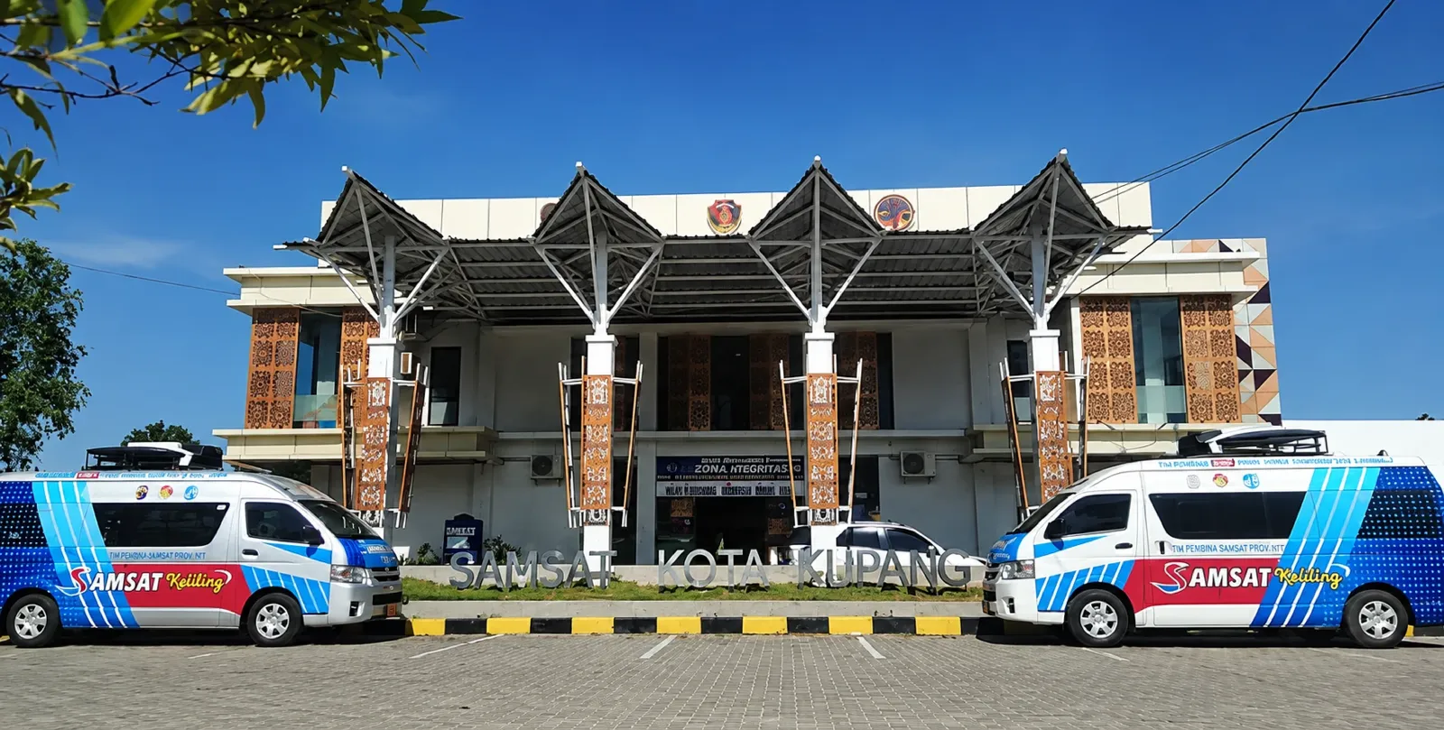 Gedung Kantor Bersama Samsat Kota Kupang dengan dua mobil Samsat Keliling di halaman depan